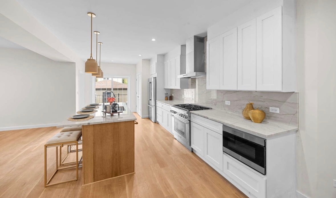 Modern white and wood kitchen with island, pendant lights, and stainless appliances