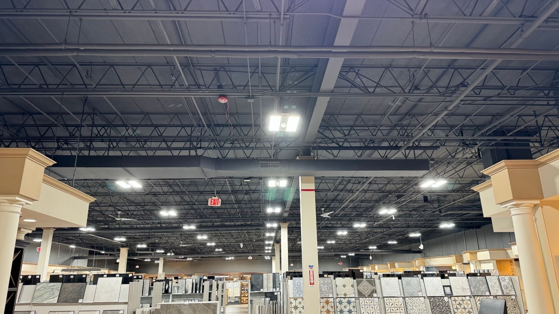 Interior of a tile and flooring showroom with exposed ceiling and bright lights