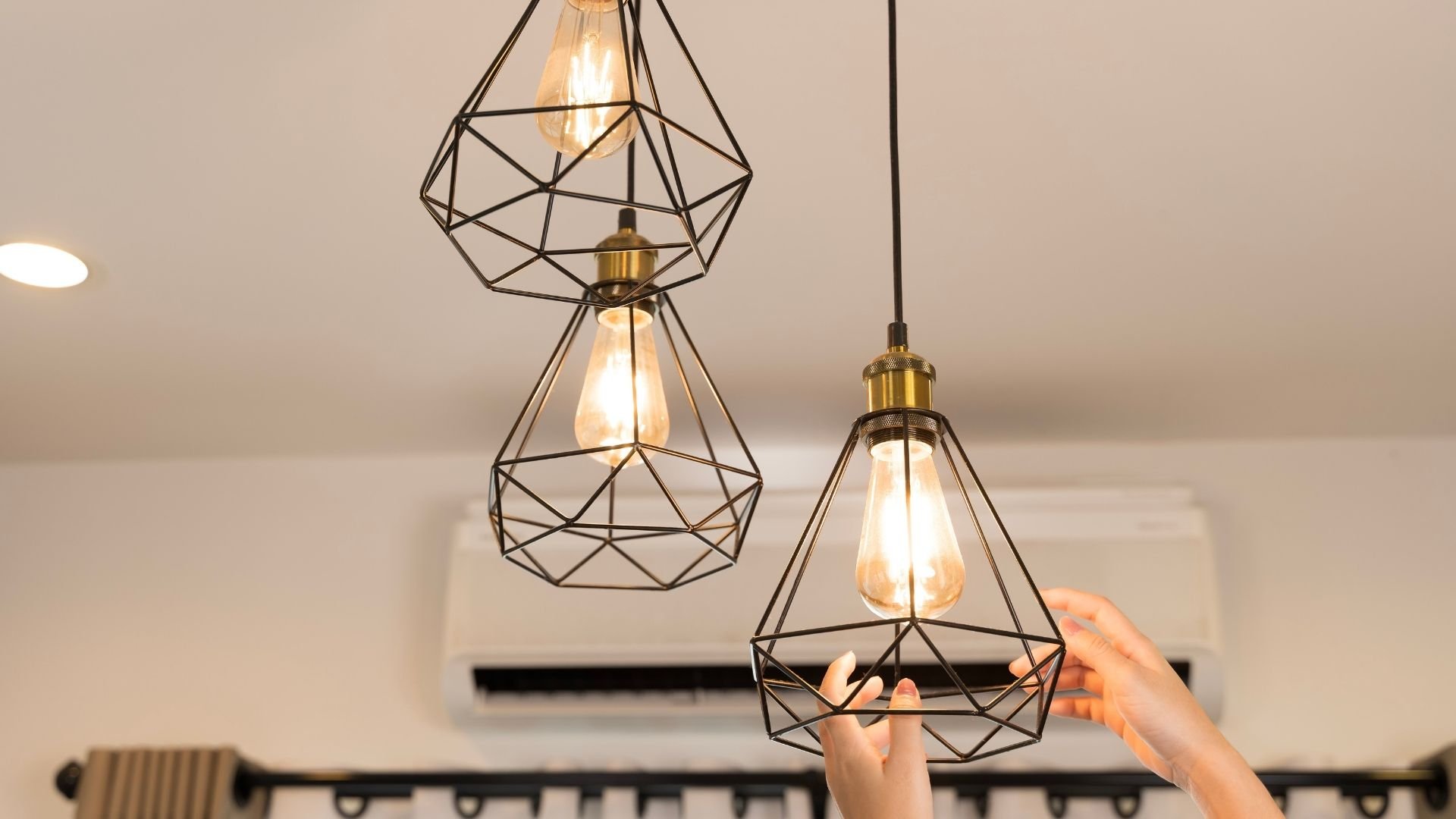 Geometric wire pendant lights with Edison bulbs hanging from ceiling