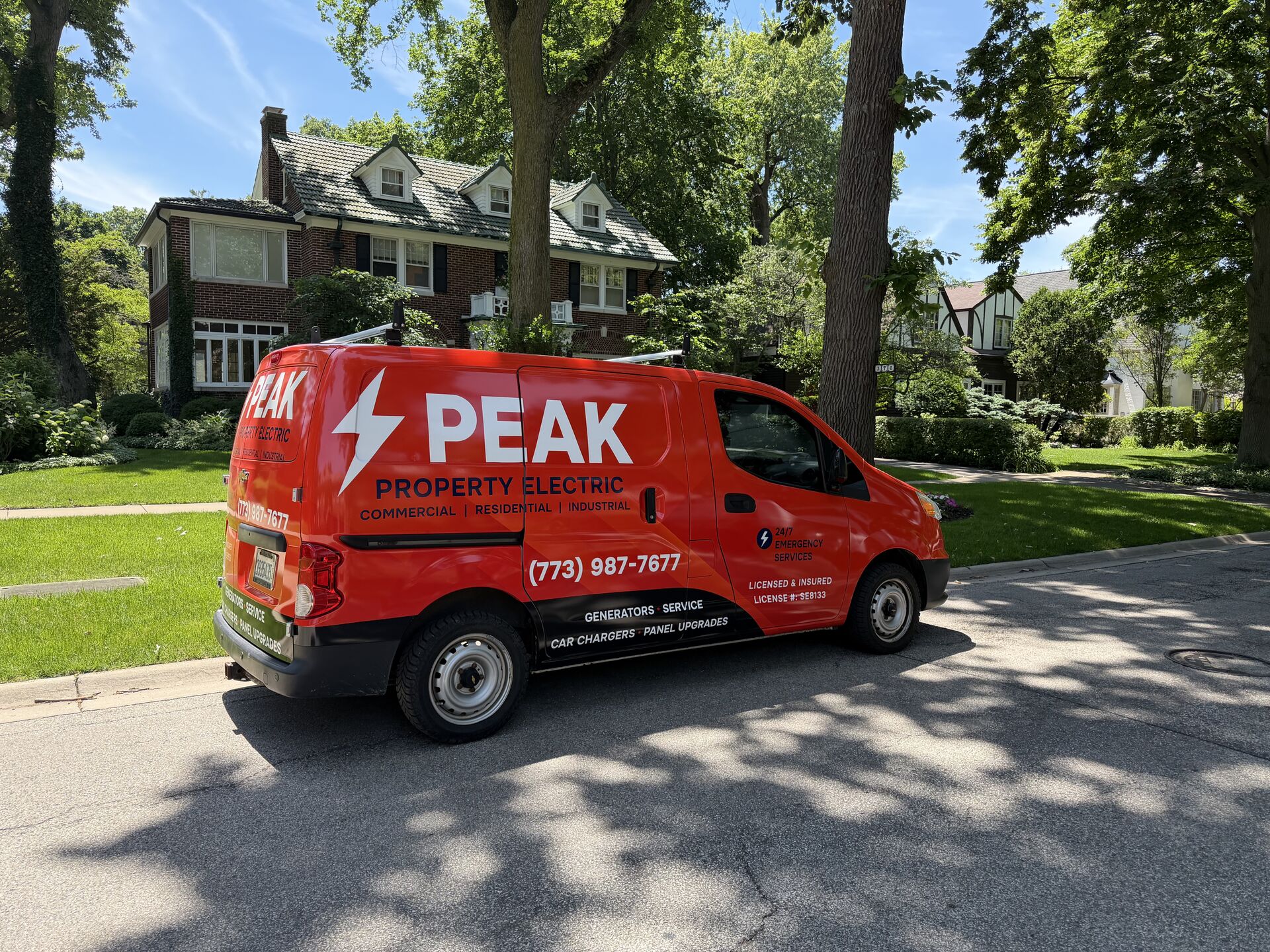 Peak Property Electric's red service van parked at a job in the North Shore