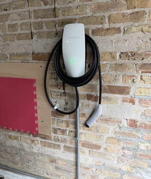 Tesla wall charger installed on a brick wall
